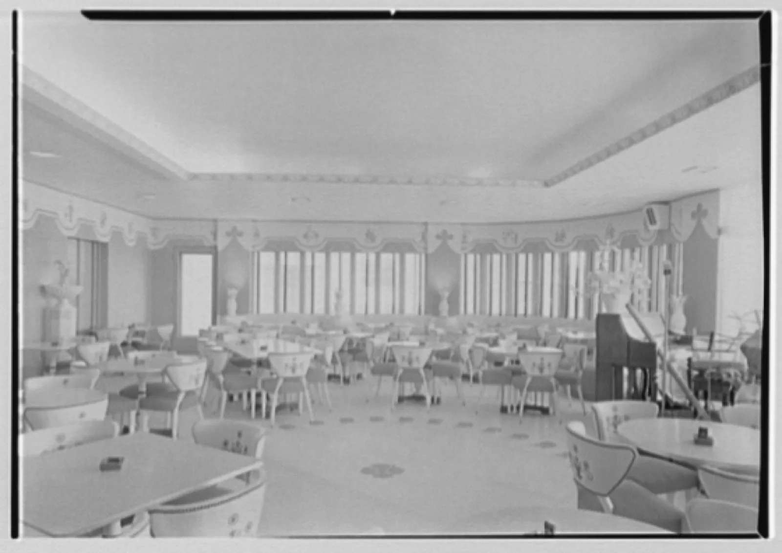 The Balkan Room of the Atlantis Hotel, Miami Beach, seen from behind the bar in 1940: a long counter, stools and a dining room beyond