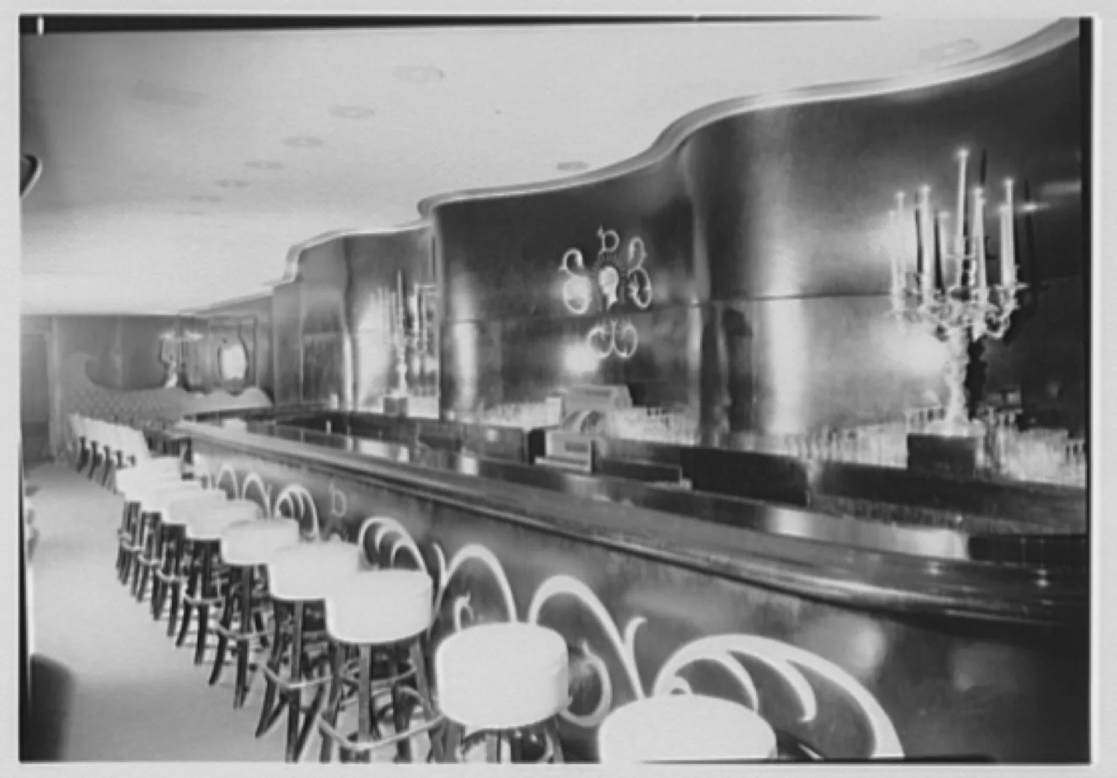 The cocktail lounge of the Hotel Delmonico, New York, 1949, with a curved bar and mirrored wall