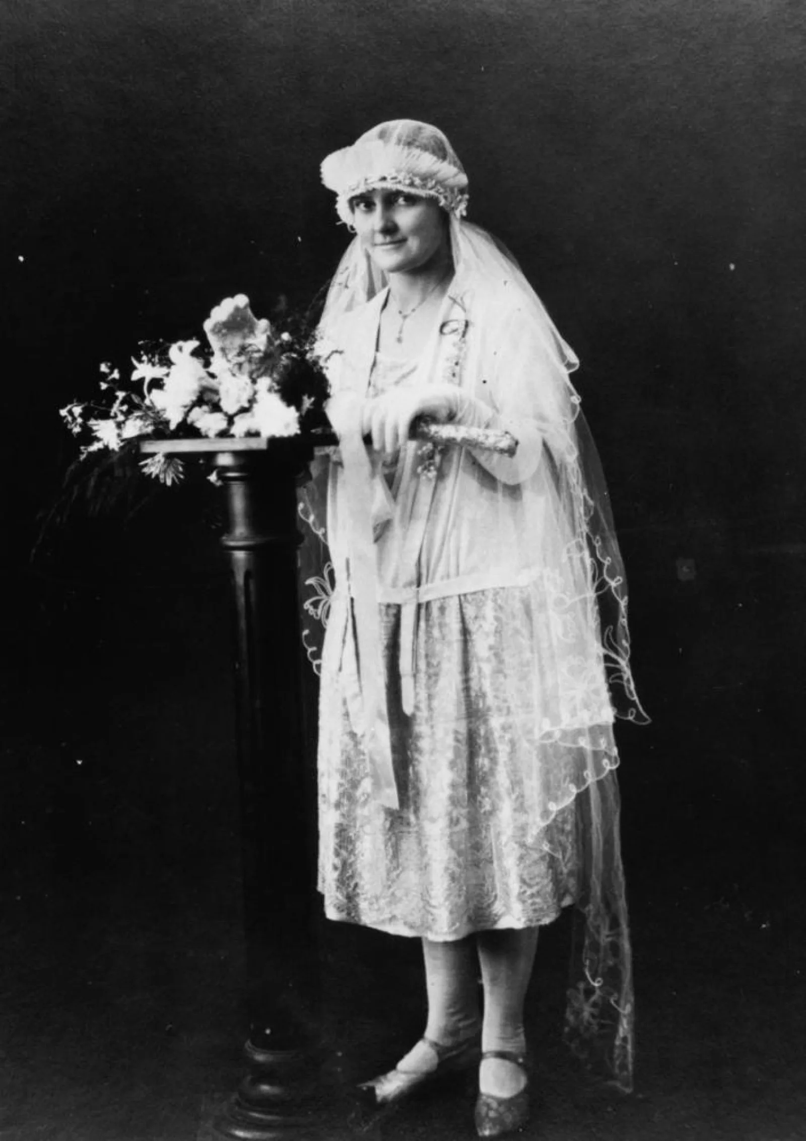 A 1920s bride in a blouson dress with a lace skirt and tulle veil