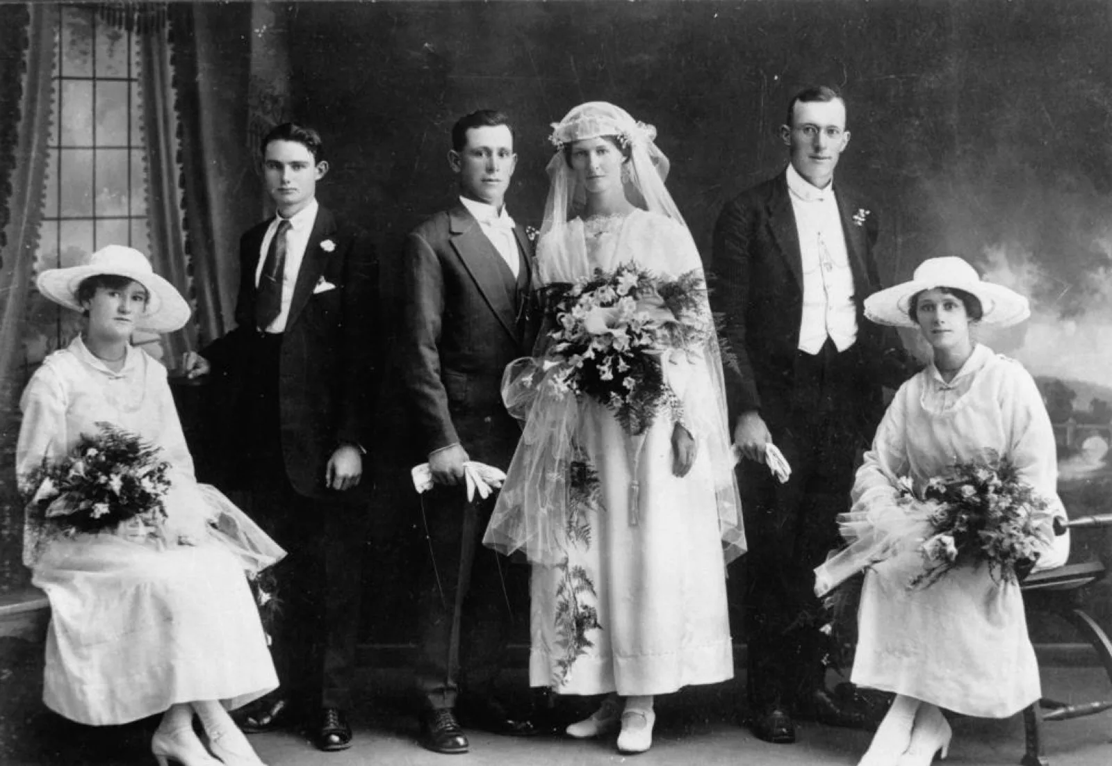 A bride, groom, groomsmen and bridesmaids in formal portrait