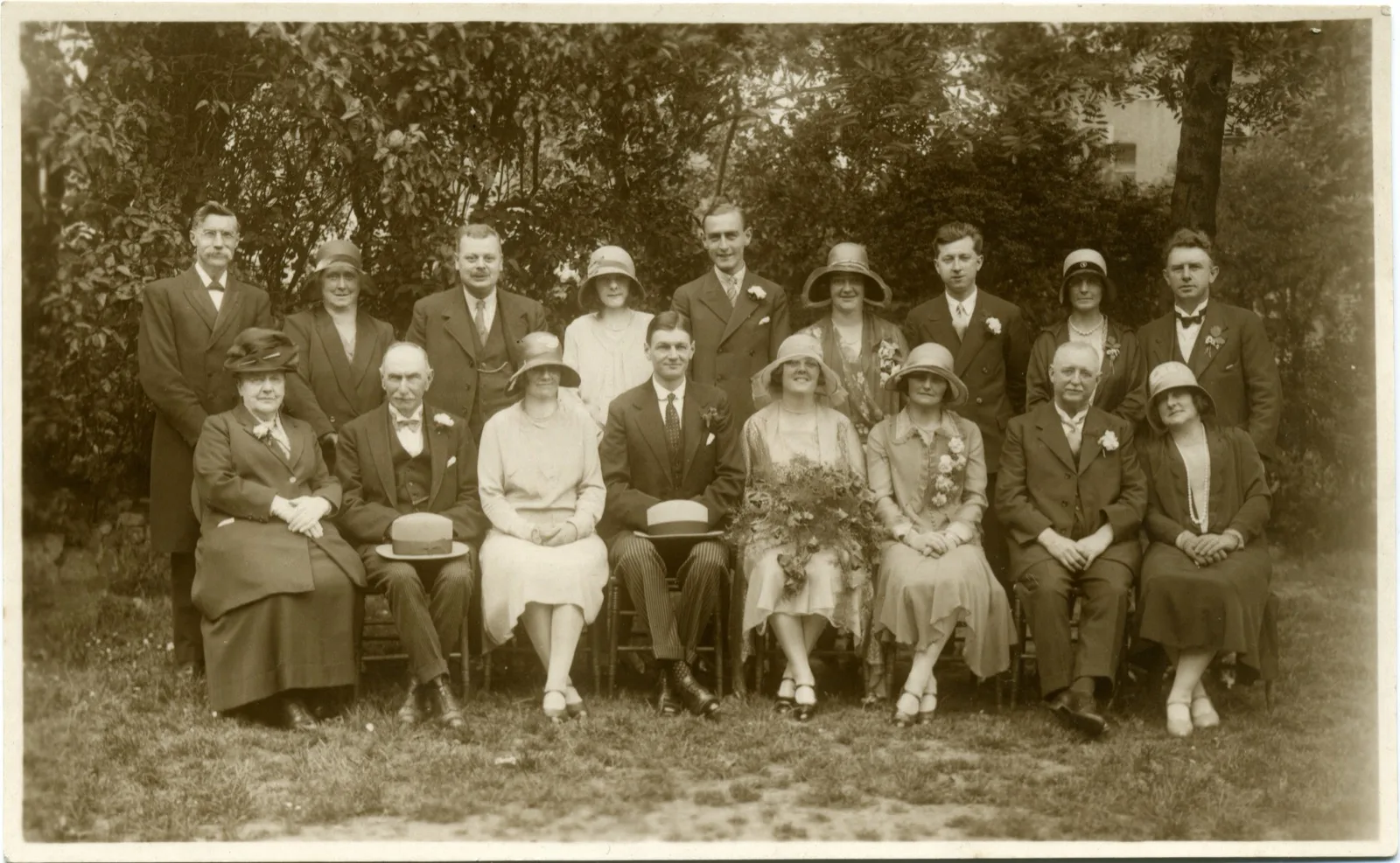 A wedding party lined up outside a house, 1920s