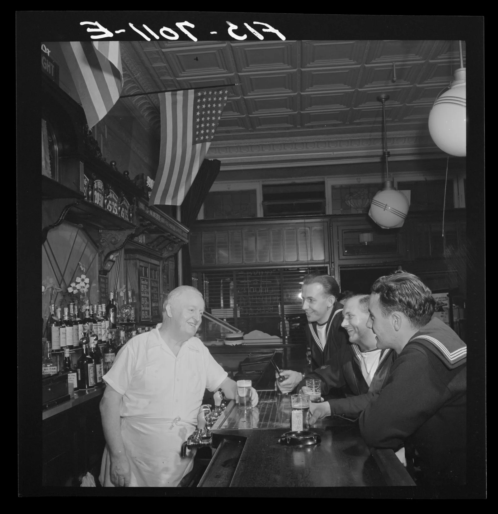 An Irish-American bartender pours beer for British sailors at a Third Avenue bar in New York, 1942