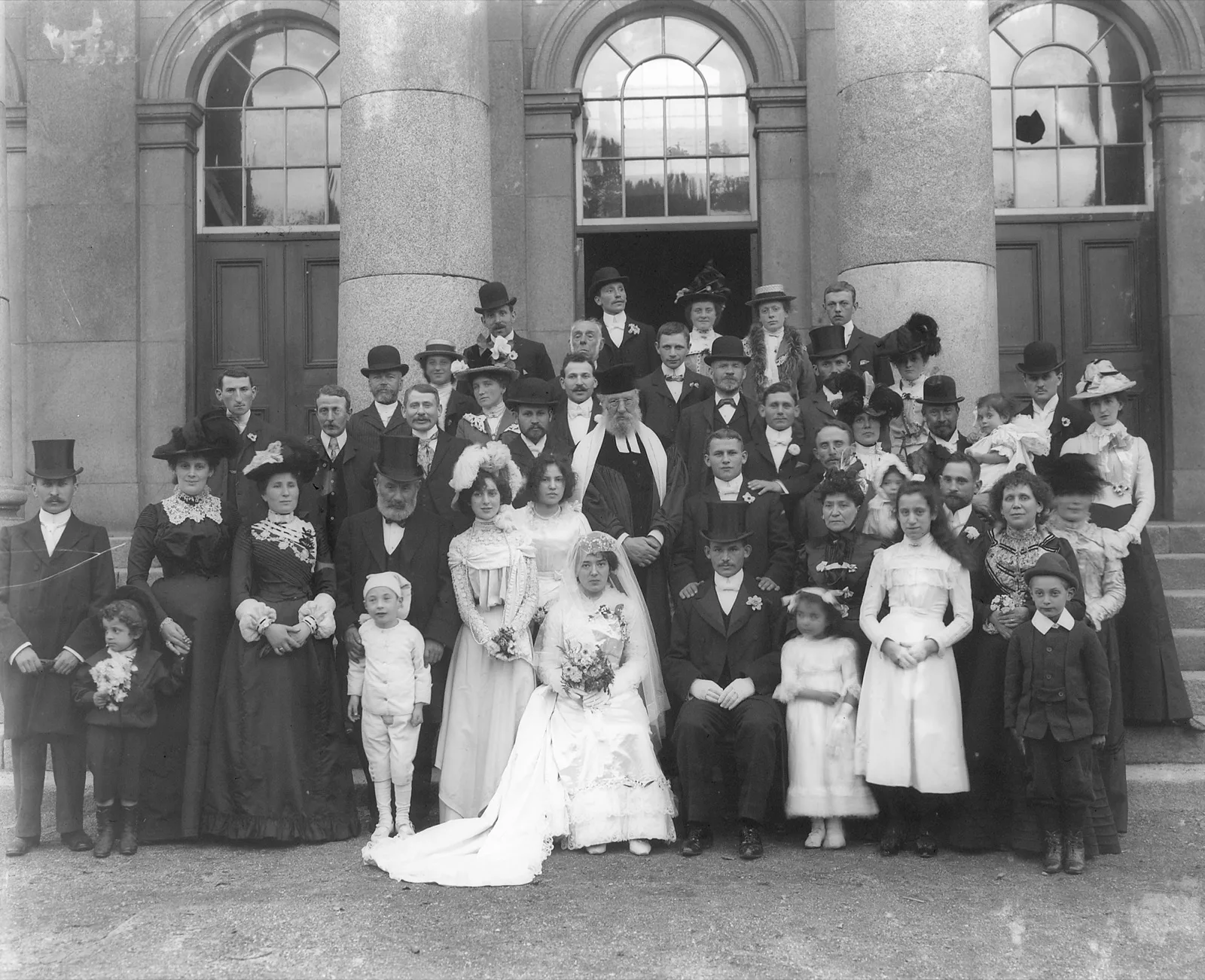 A wedding party under a canopy outside a courthouse, 1901