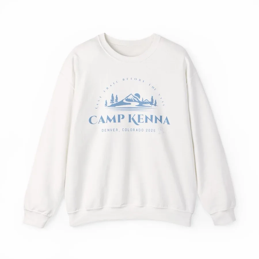 A cream crewneck sweatshirt printed with a line drawing of mountains and the words Camp Kenna, Denver Colorado